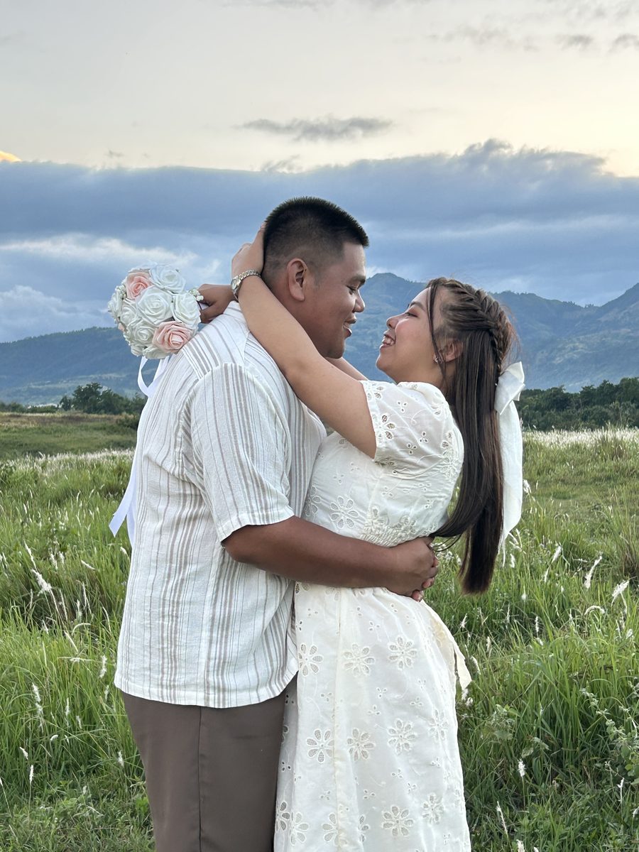 The couple embracing at sunset